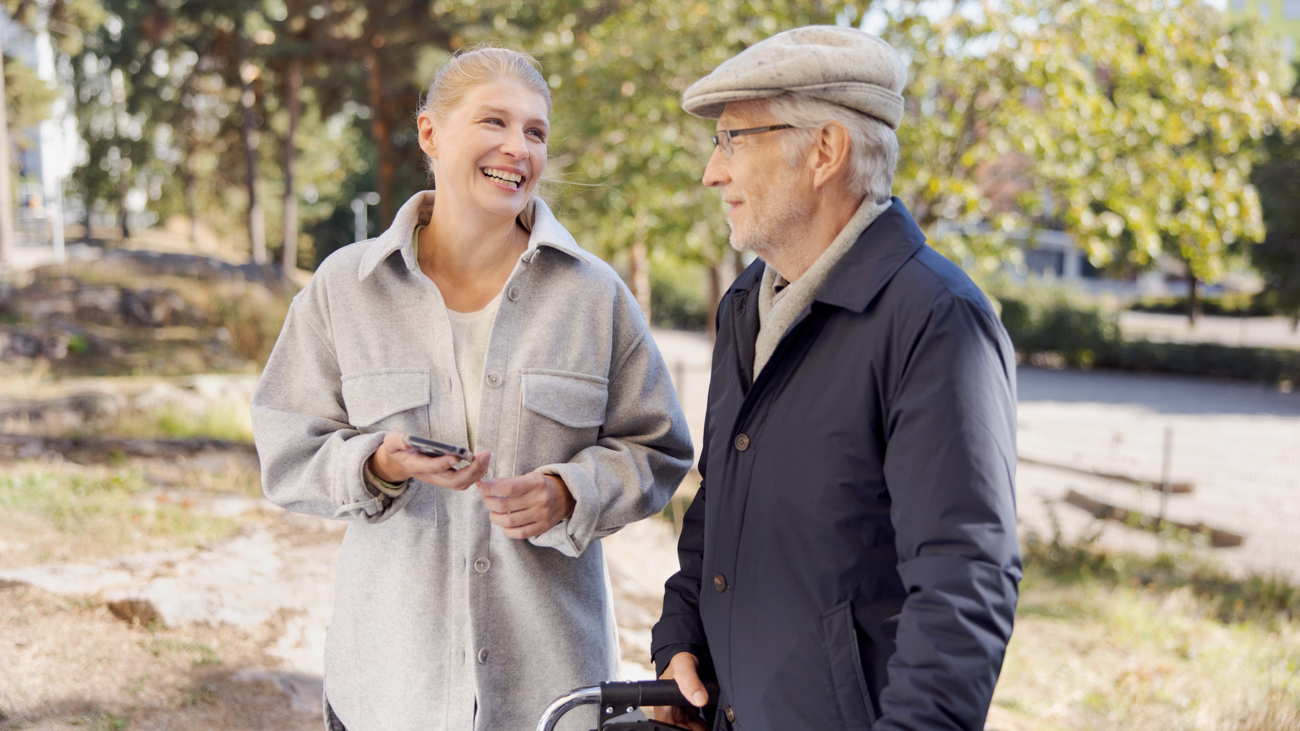 A woman and an old man in a park.