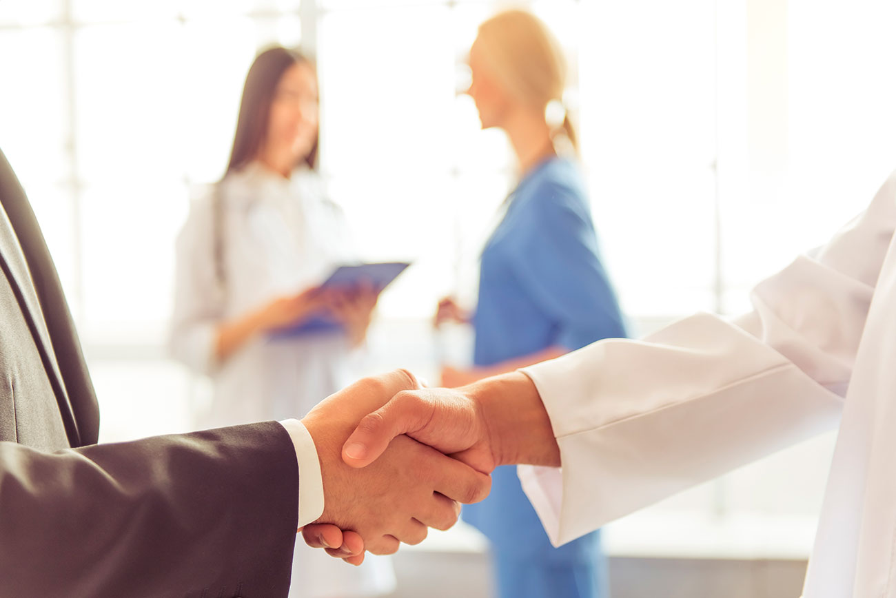 An illustration of a handshake between a doctor and a patient.