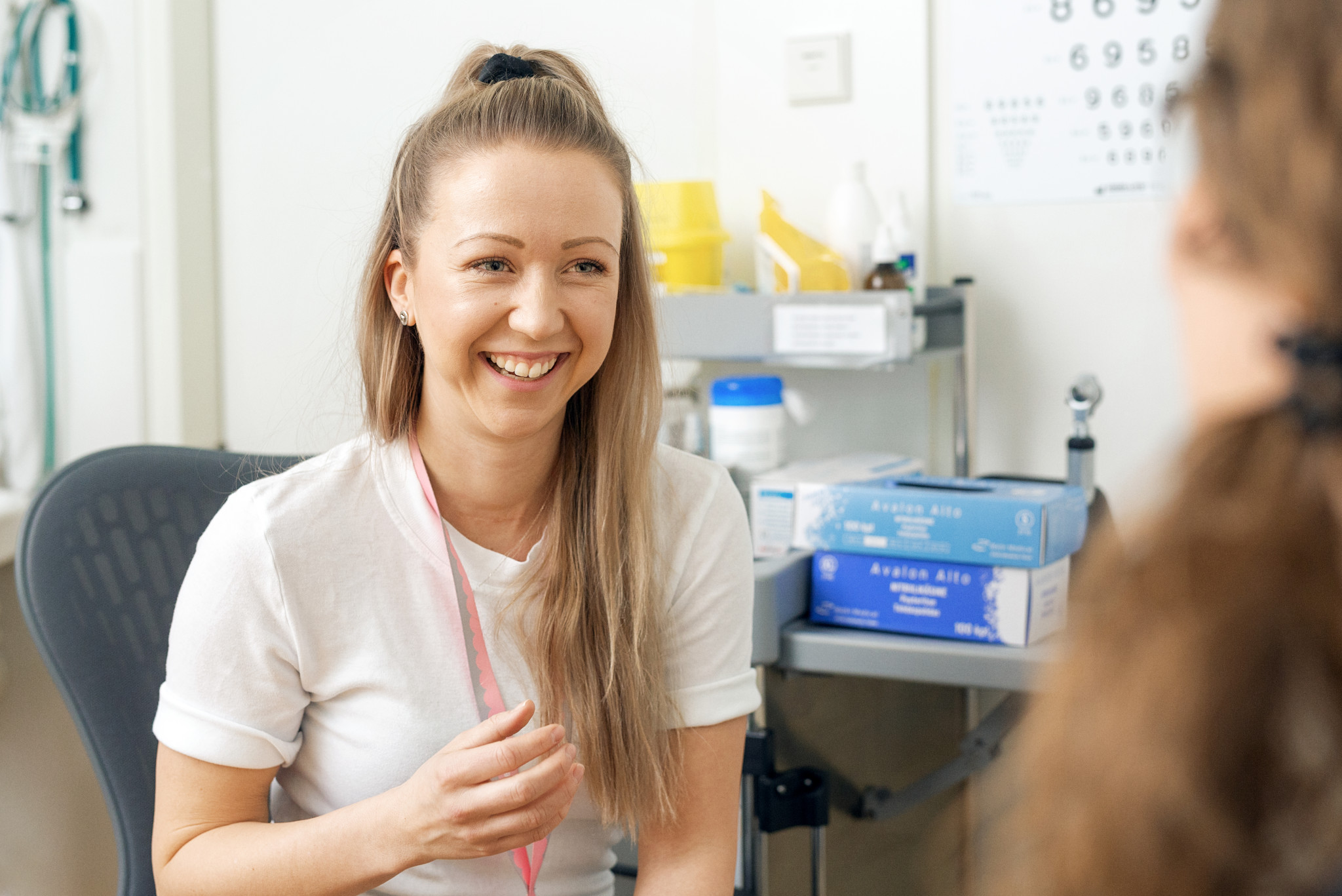 A cheerful healthcare professional is talking to a patient.