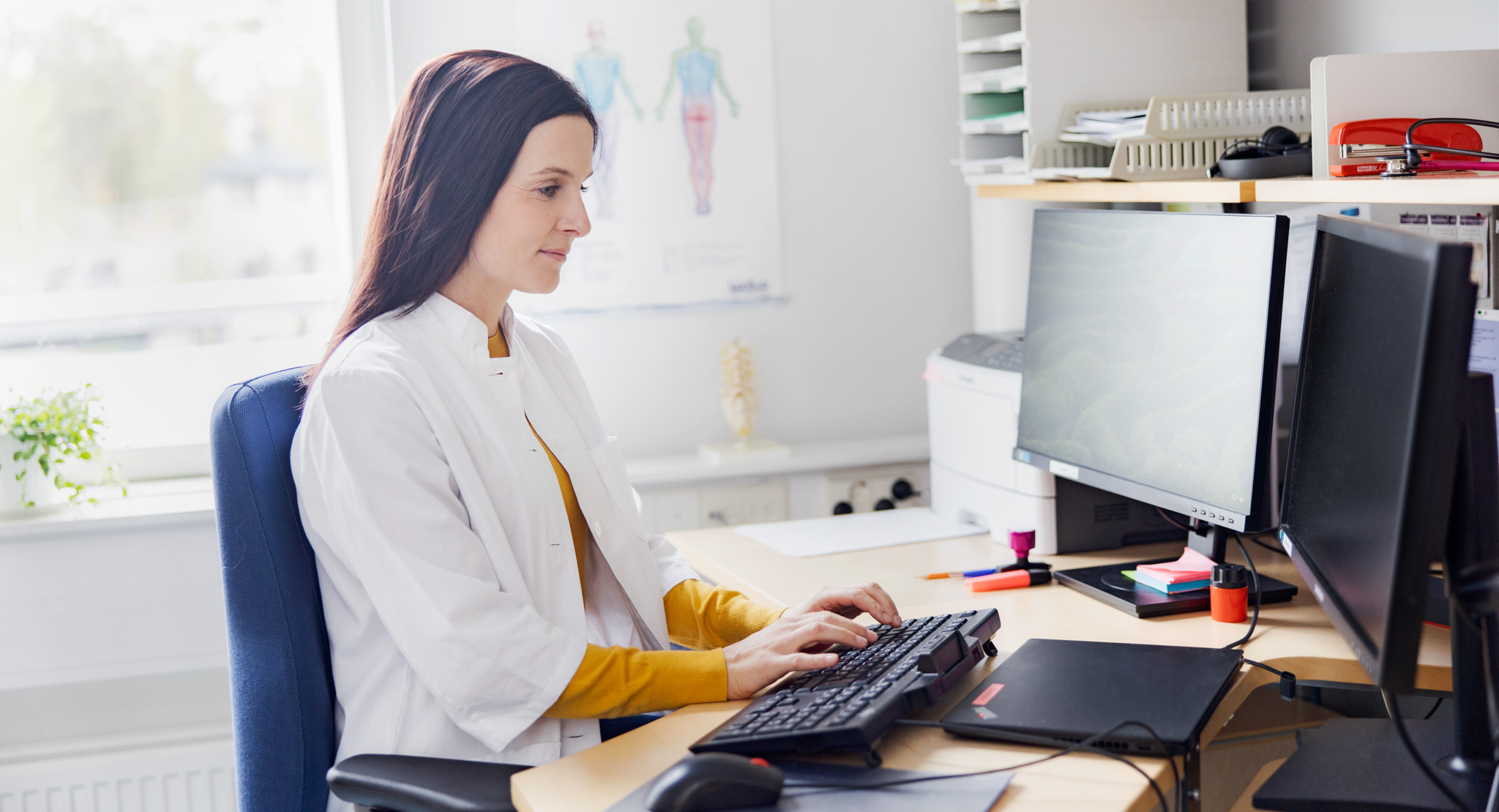 A doctor is working on a computer.