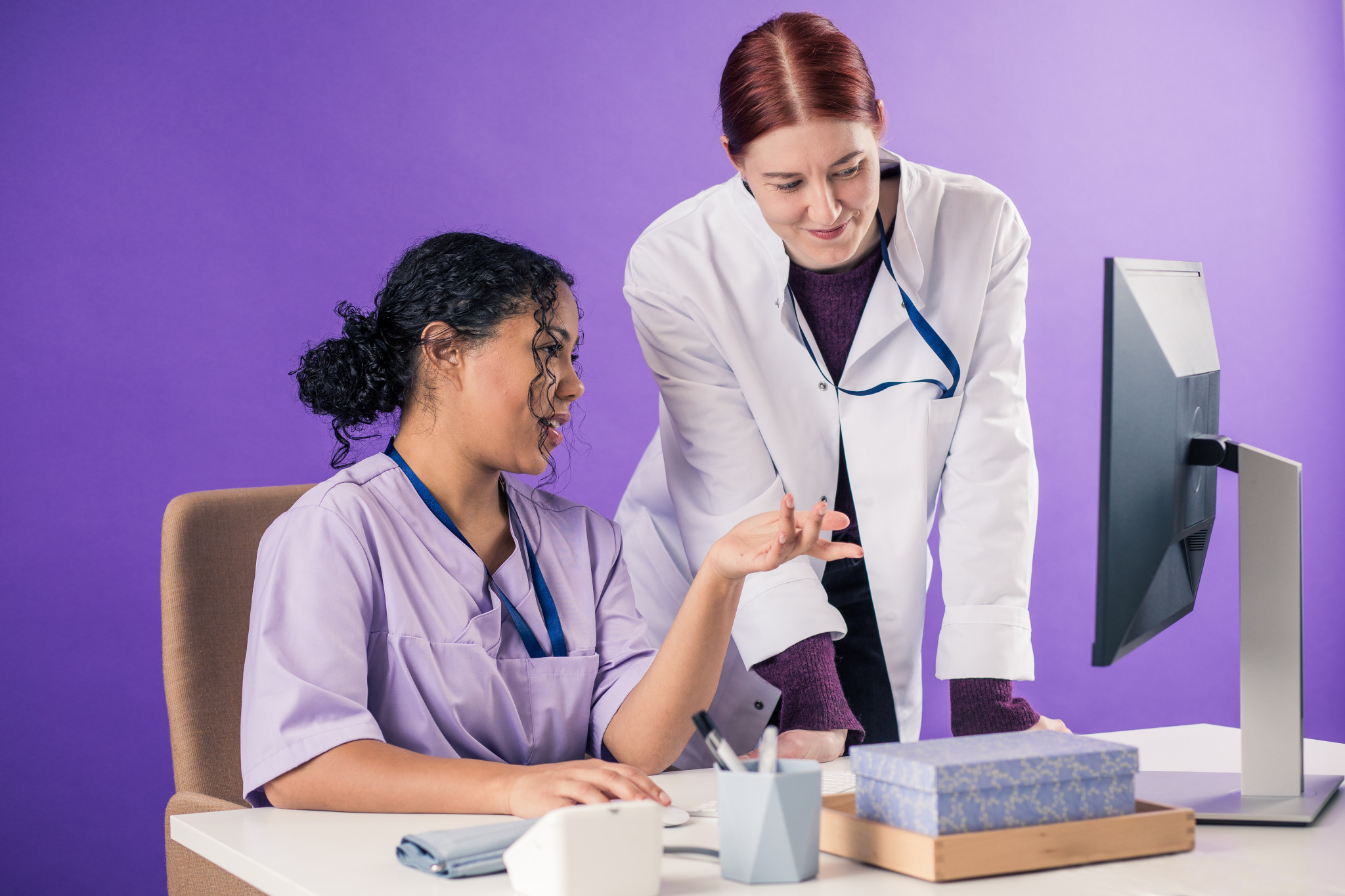Lääkäri ja hoitaja tietokoneen ääressä.