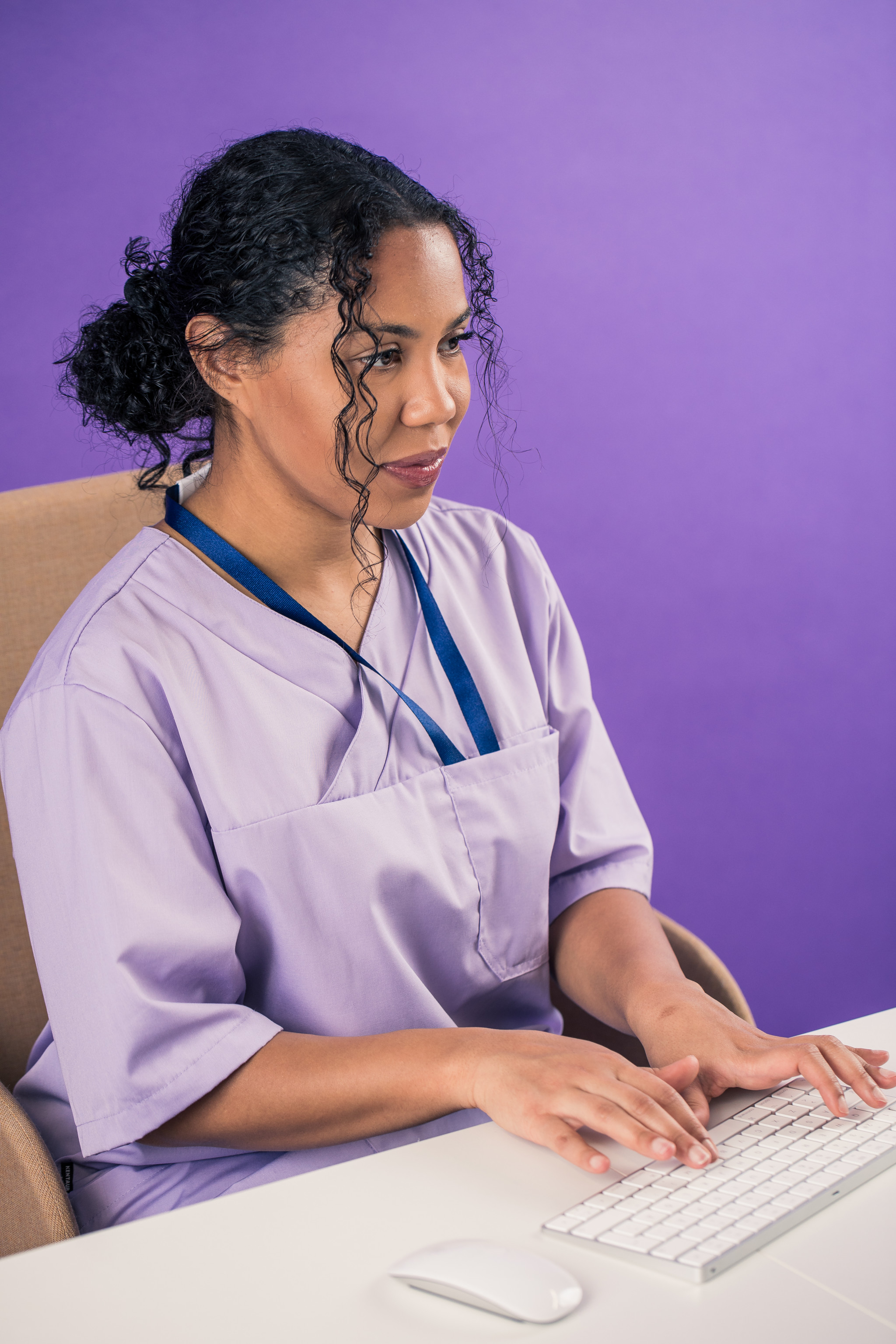 Terveydenhuollon ammattilainen istuu työpöydän ääressä.