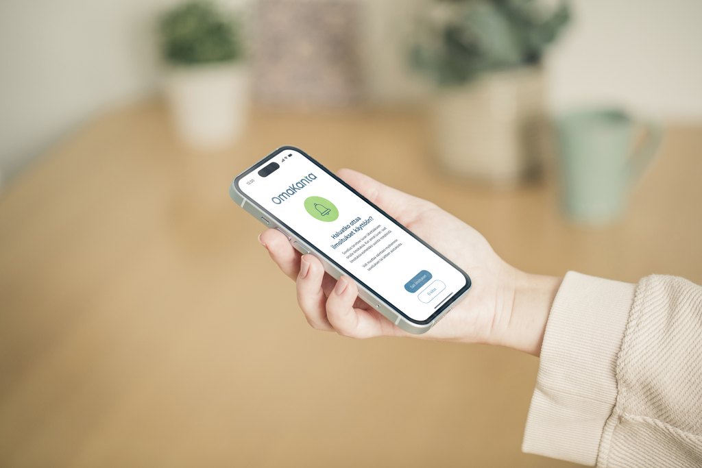 Kuvassa näkyy käsi ja puhelin, jonka näytöllä on OmaKanta-sovellus.