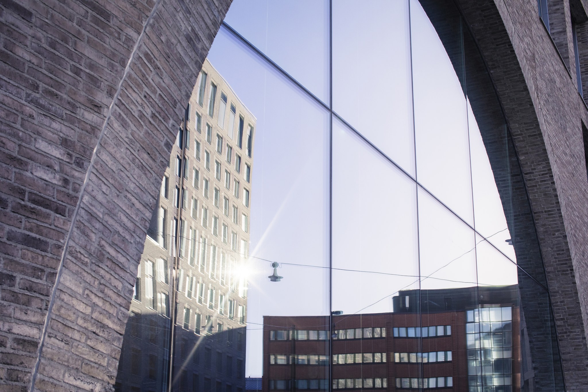 Solsken och höghus reflekteras i ett fönster