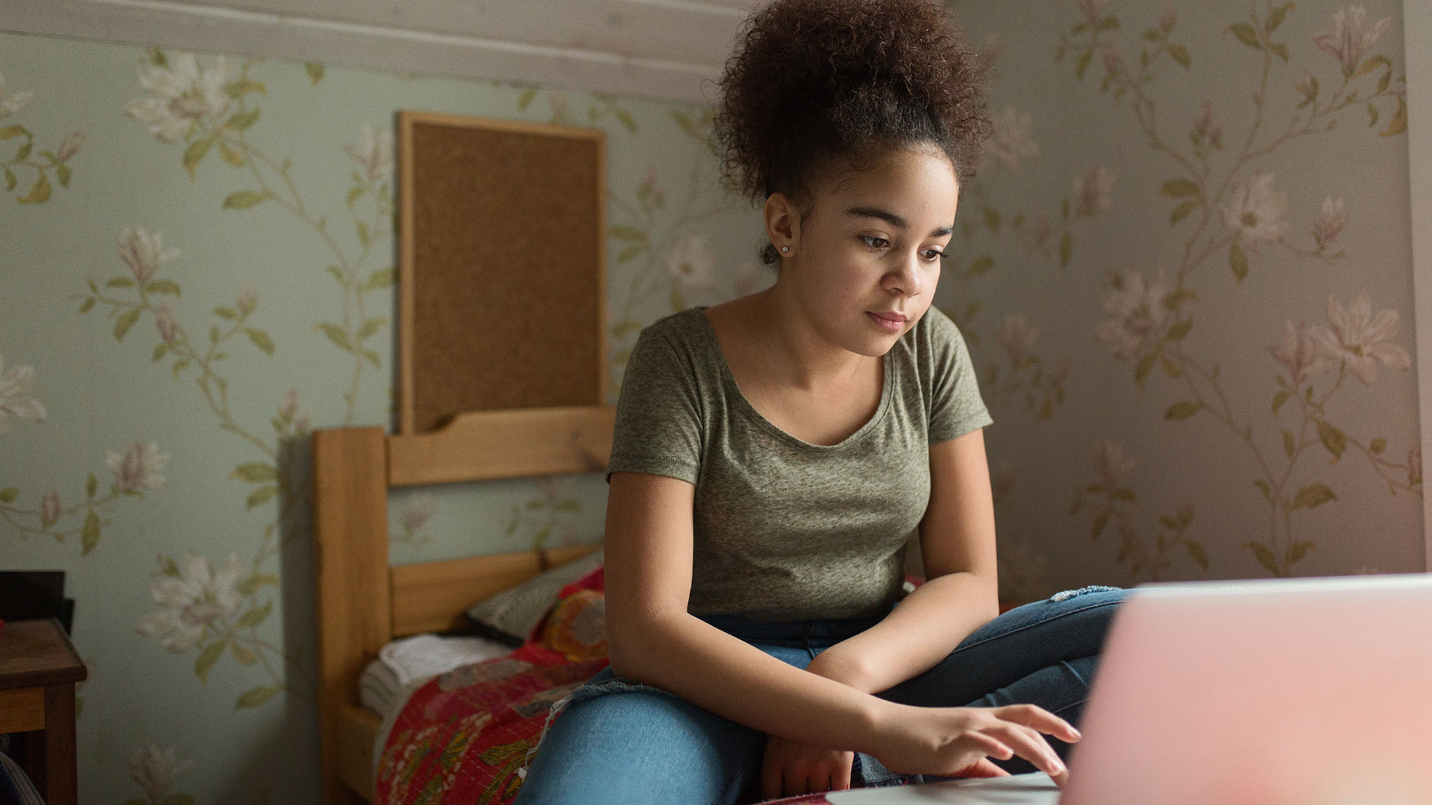 A young woman is watching her computer.